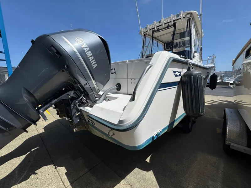 Slide: The Image of 1990 Grady-White Marlin 28 boat with Yamaha outboard motor, docked under clear blue sky. - 4