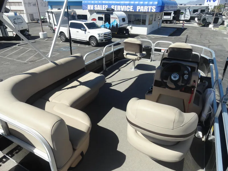 Slide: The Image of 2019 Sun Tracker Bass Buggy 18 DLX pontoon boat with beige seating, parked near RV sales. - 11