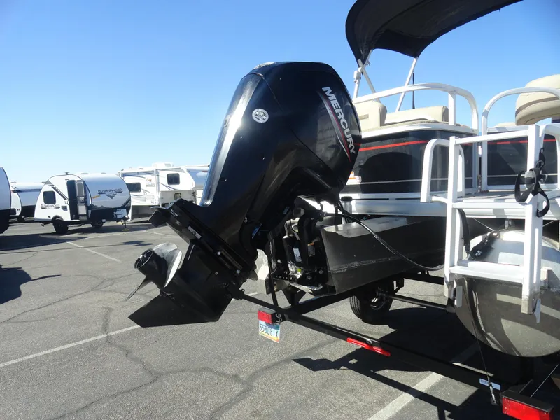 Slide: The Image of 2019 Sun Tracker Bass Buggy 18 DLX pontoon boat with Mercury outboard motor in a parking lot. - 22