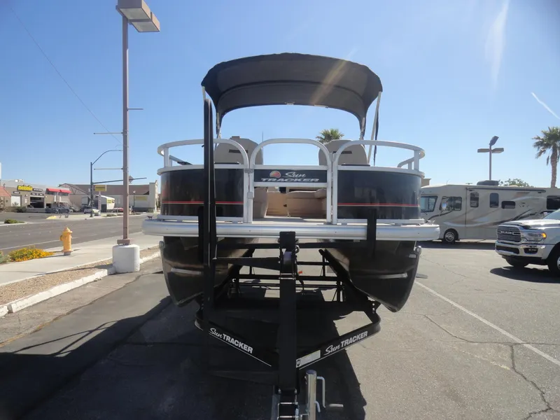 Slide: The Image of 2019 Sun Tracker Bass Buggy 18 DLX pontoon boat on trailer in sunny parking lot. - 4