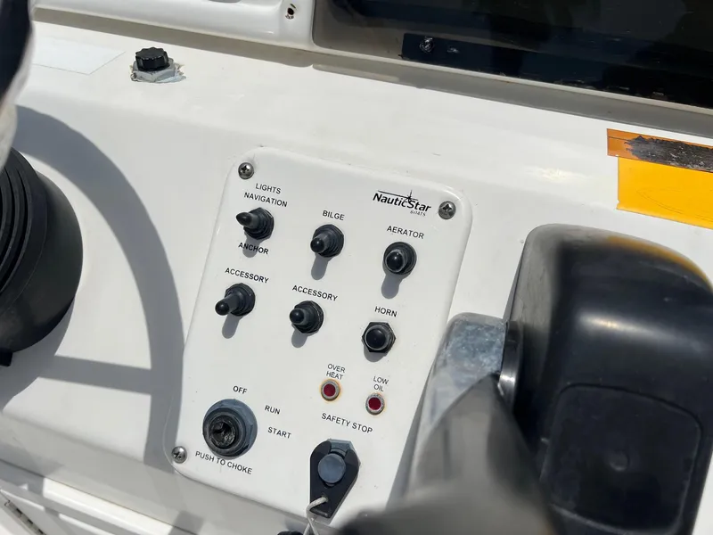 Slide: The Image of Control panel of a 2006 NauticStar 2110 Nautic Bay boat with various switches and buttons. - 9