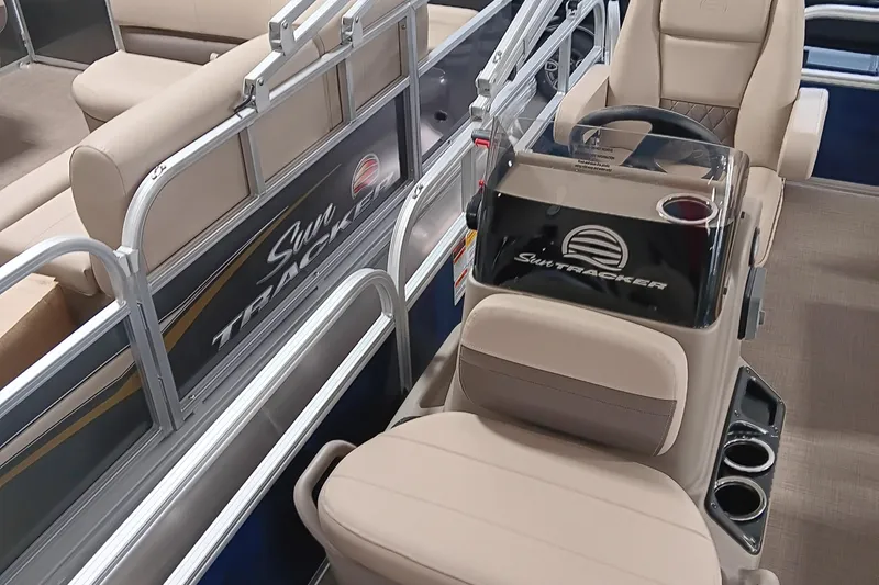 Slide: The Image of 2025 Sun Tracker Bass Buggy 16 XL Select interior with beige seating and steering console. - 6