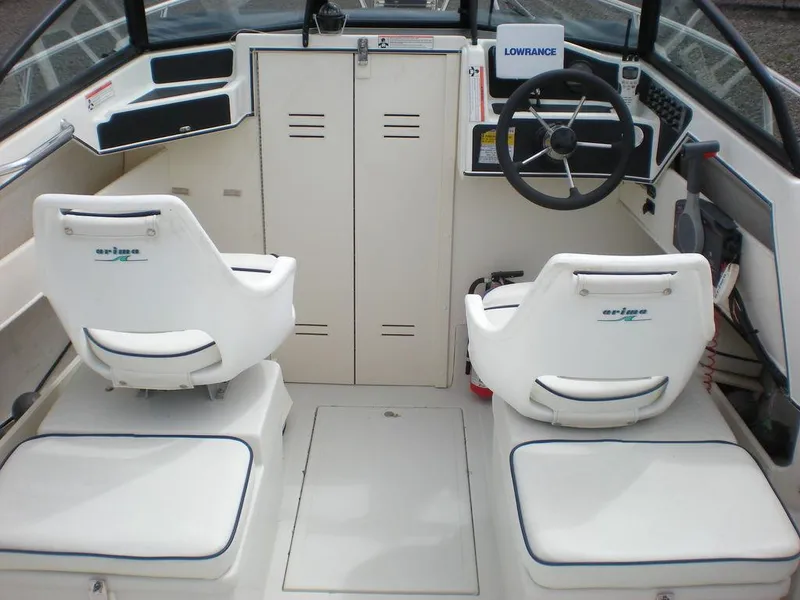 Slide: The Image of Interior of 2010 Arima SEA CHASER boat with steering wheel and seating. - 4