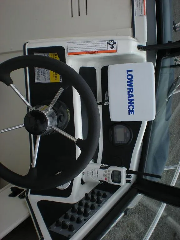 Slide: The Image of 2010 Arima SEA CHASER boat dashboard with steering wheel and Lowrance navigation system. - 8