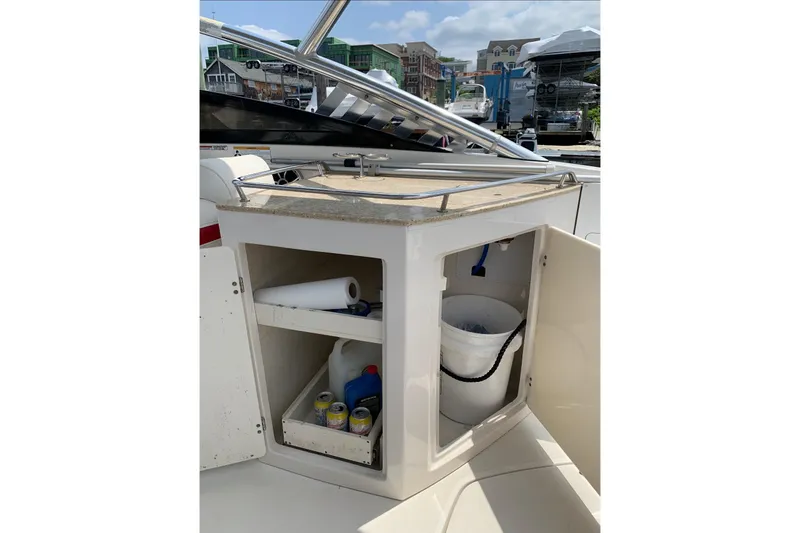 Slide: The Image of 2012 Monterey M5 MSX Sport Boat interior storage with supplies and open cabinet. - 11