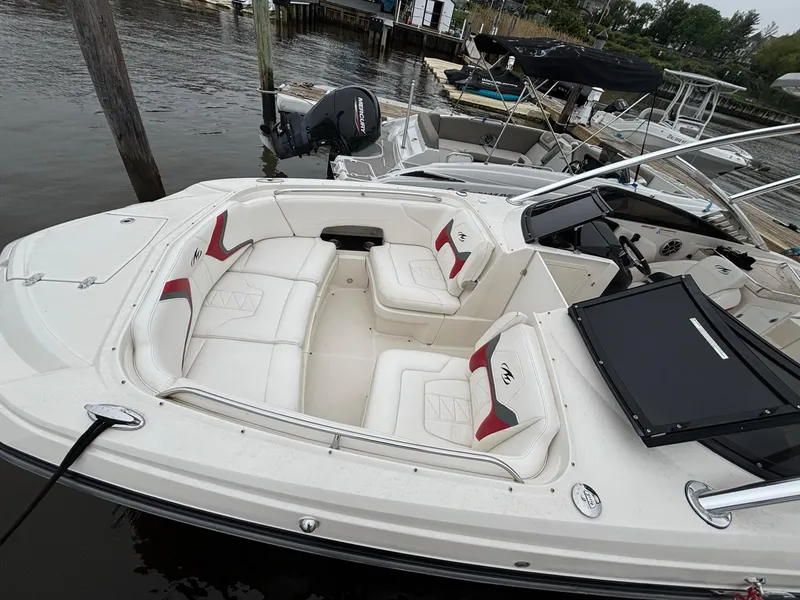 Slide: The Image of 2012 Monterey M5 MSX Sport Boat with white seating docked at marina. - 2
