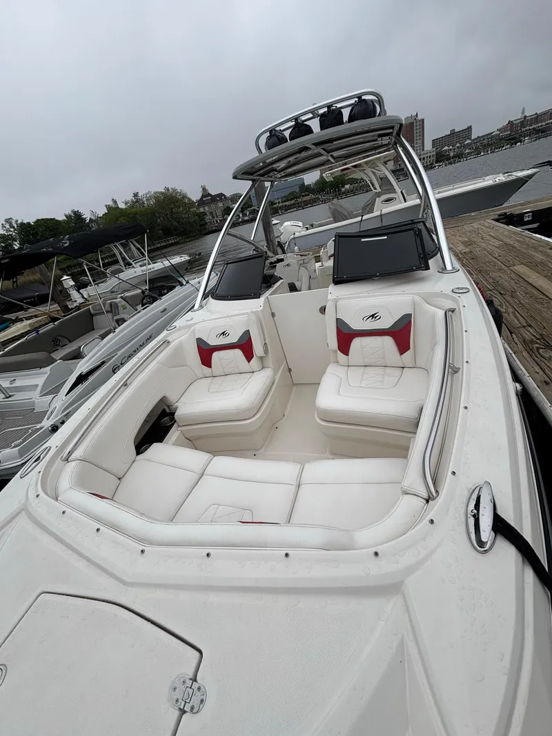 Slide: The Image of 2012 Monterey M5 MSX Sport Boat with white seating and sleek design at a marina. - 3