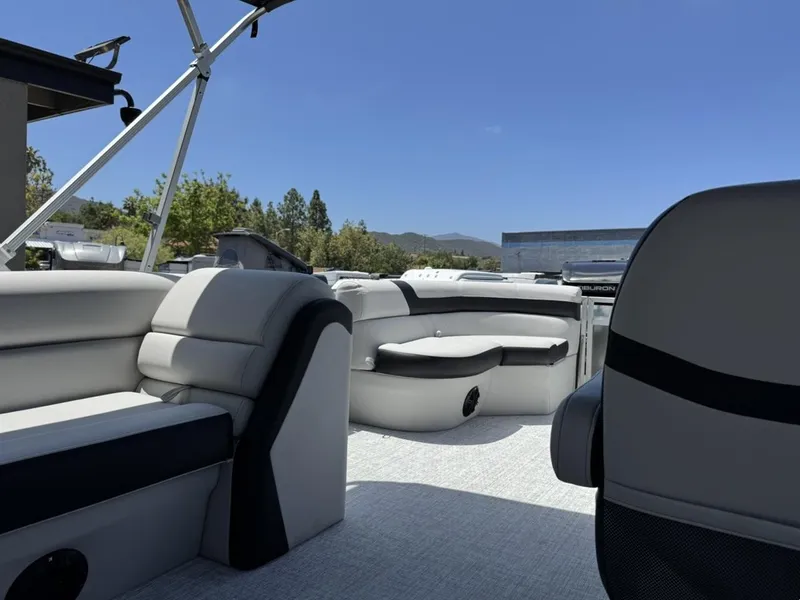 Slide: The Image of 2025 South Bay 18CR SE S Cruise pontoon boat interior with seating, under clear blue sky. - 15