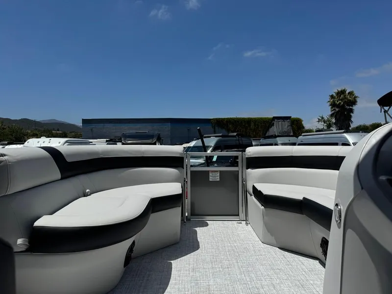 Slide: The Image of 2025 South Bay 18CR SE S Cruise boat interior with plush seating under clear blue sky. - 17