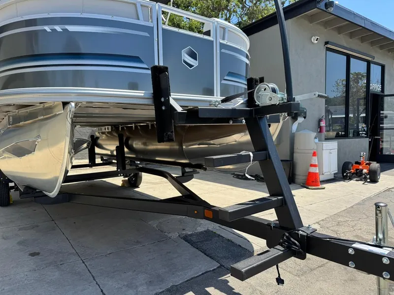 Slide: The Image of 2025 South Bay 18CR SE S Cruise pontoon boat on trailer, parked outdoors. - 27
