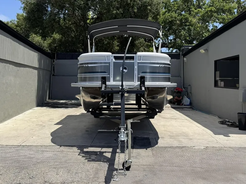 Slide: The Image of 2025 South Bay 18CR SE S Cruise pontoon boat on trailer in driveway. - 29