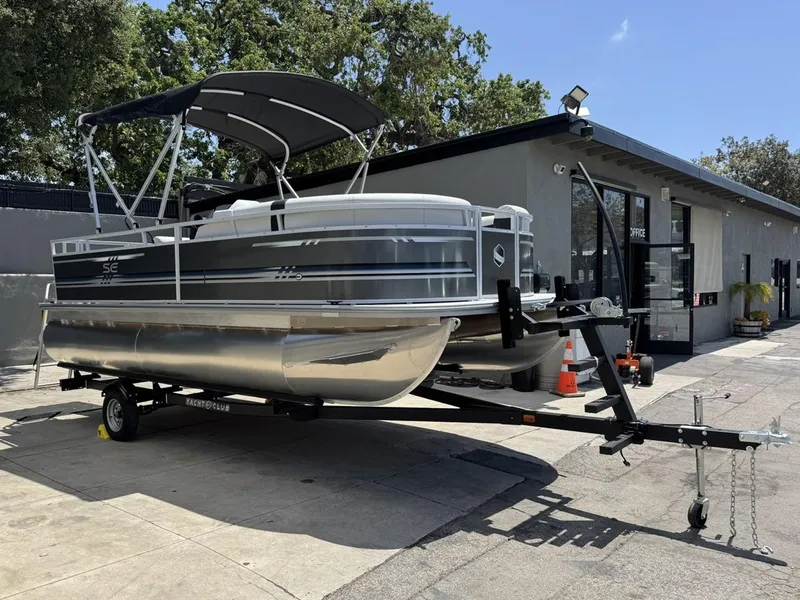 Slide: The Image of 2025 South Bay 18CR SE S Cruise pontoon boat on trailer, parked outdoors. - 3