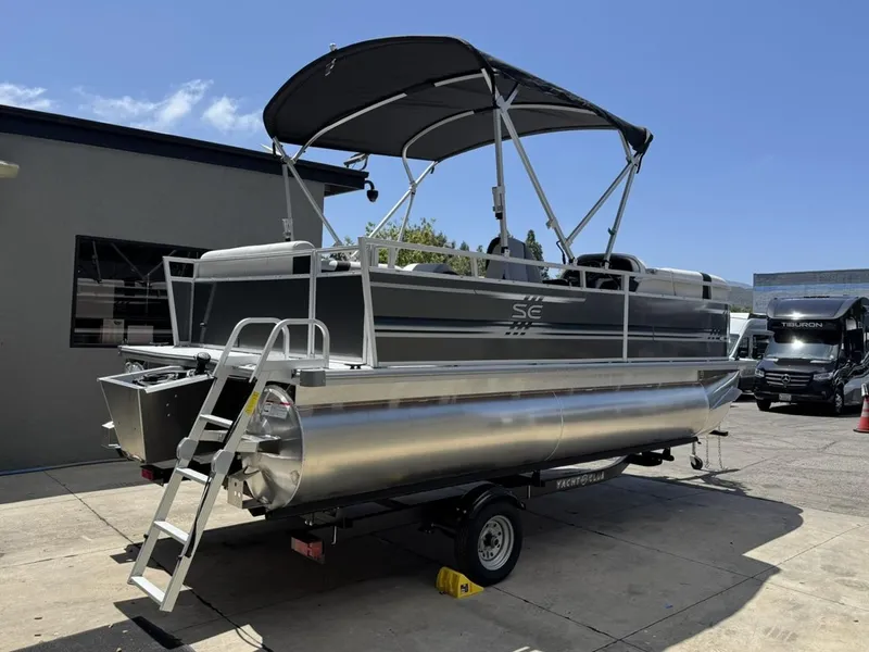 Slide: The Image of 2025 South Bay 18CR SE S Cruise pontoon boat on trailer, parked outdoors. - 4