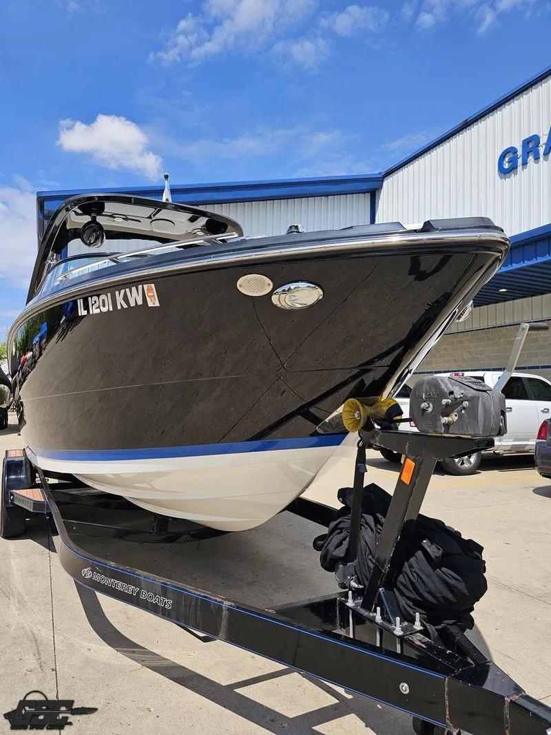 Slide: The Image of 2018 Monterey 258 Super Sport boat on trailer, parked outdoors under blue sky. - 11