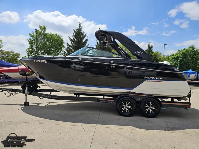 Slide: The Image of 2018 Monterey 258 Super Sport boat on trailer, parked outdoors under a blue sky. - 15