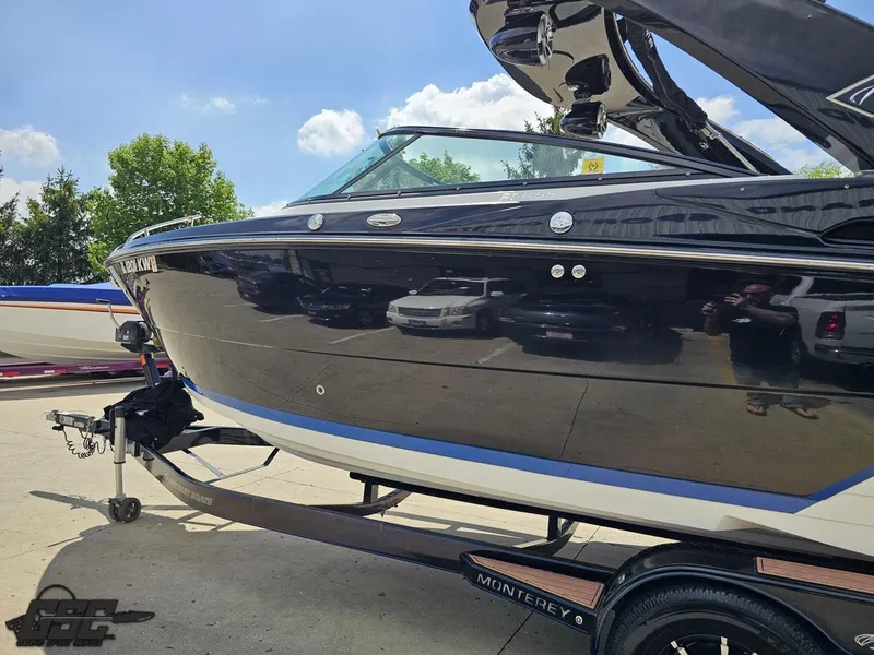 Slide: The Image of 2018 Monterey 258 Super Sport boat on trailer, sleek black design, sunny day. - 16