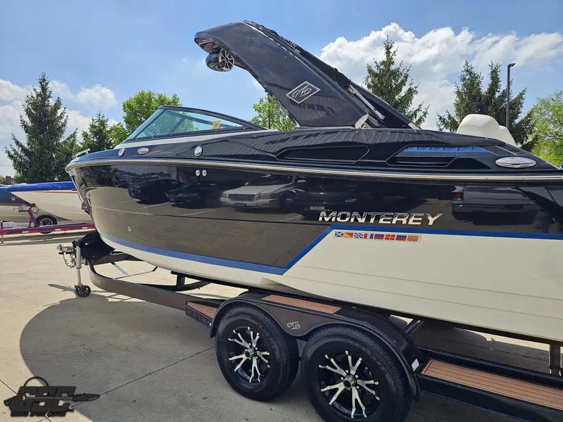 Slide: The Image of 2018 Monterey 258 Super Sport boat on trailer, sleek black and white design, sunny day. - 19