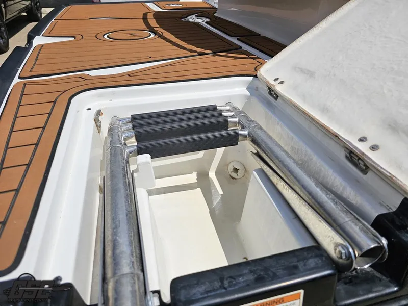 Slide: The Image of 2018 Monterey 258 Super Sport boat ladder compartment with teak-style decking. - 24