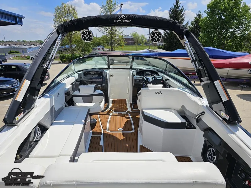 Slide: The Image of 2018 Monterey 258 Super Sport boat interior with seating and steering wheel, docked outdoors. - 31