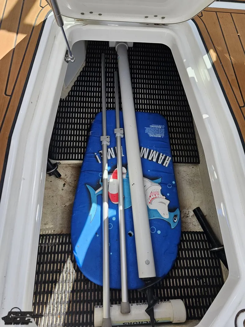 Slide: The Image of Storage compartment in a 2018 Monterey 258 Super Sport boat with equipment and a shark-themed float. - 40