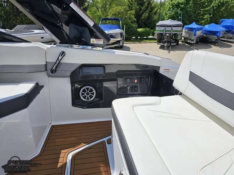 Slide: The Image of Interior of a 2018 Monterey 258 Super Sport boat with white seating and wood flooring. - 41