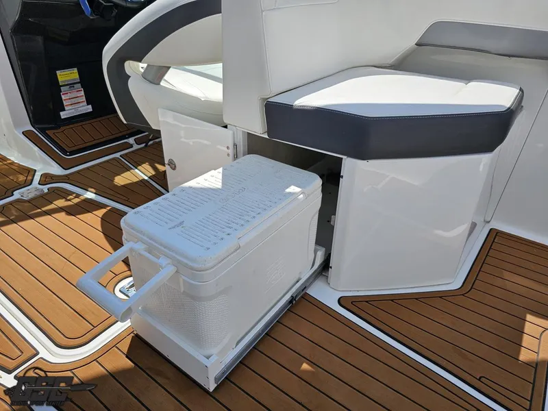 Slide: The Image of 2018 Monterey 258 Super Sport boat interior with a pull-out cooler on teak flooring. - 46