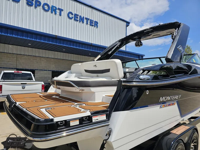 Slide: The Image of 2018 Monterey 258 Super Sport boat at dealership, showcasing sleek design and spacious deck. - 6