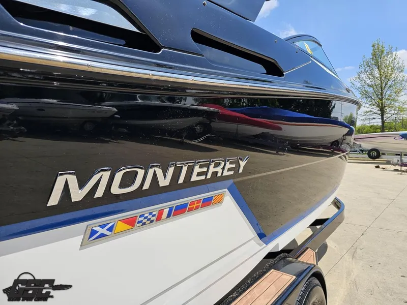 Slide: The Image of 2018 Monterey 258 Super Sport boat with nautical flags, parked outdoors on a sunny day. - 7