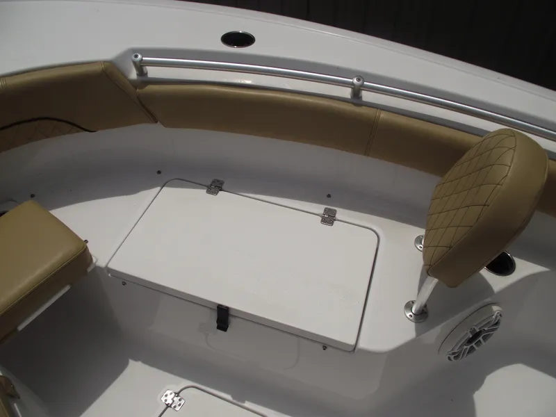 Slide: The Image of 2021 Sportsman Open 212 Center Console boat interior with tan seating and storage compartment. - 12