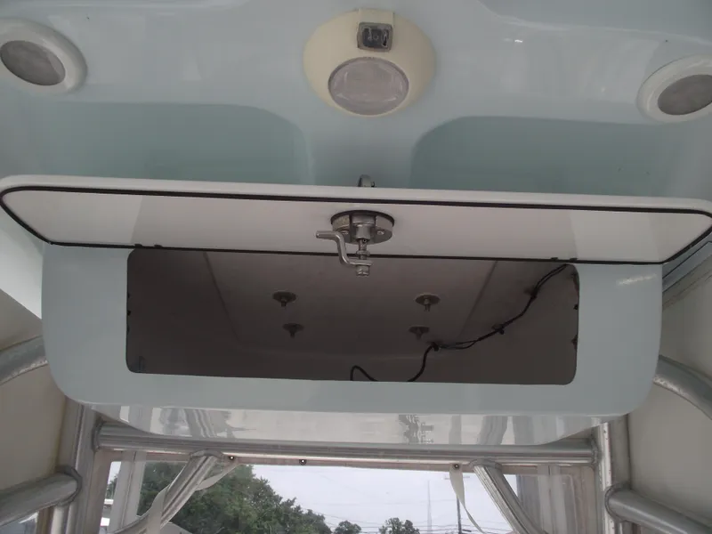 Slide: The Image of 2021 Sportsman Open 212 Center Console boat storage compartment with open hatch and visible wiring. - 33