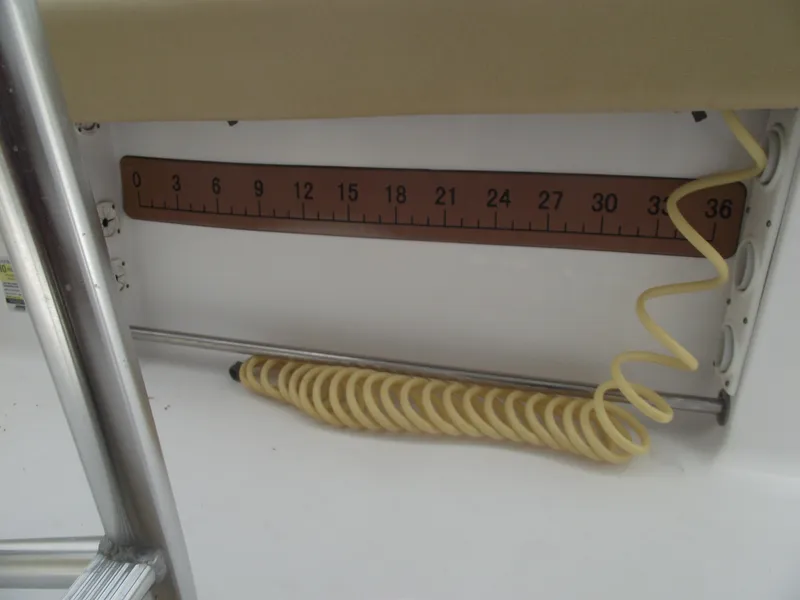 Slide: The Image of Ruler and coiled hose on 2021 Sportsman Open 212 Center Console boat. - 35