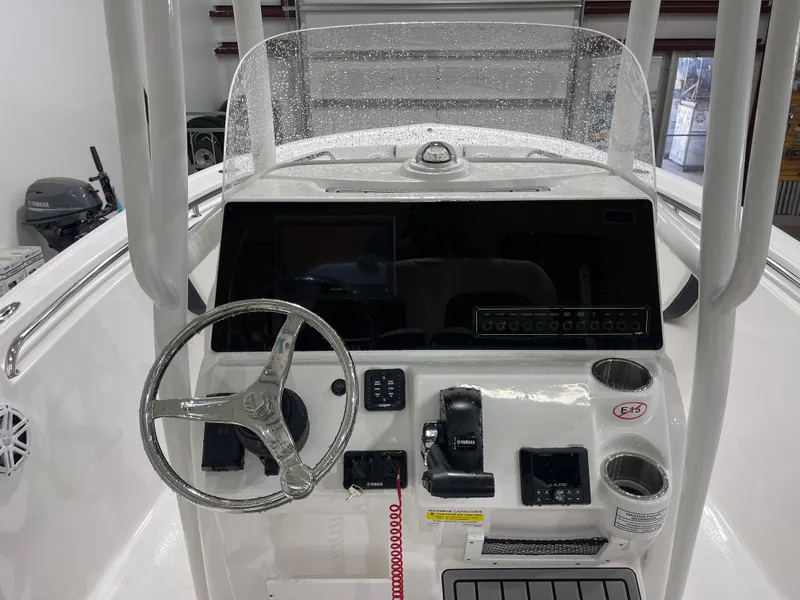 Slide: The Image of 2025 Tidewater 210LXF boat dashboard with steering wheel and controls in a garage setting. - 20