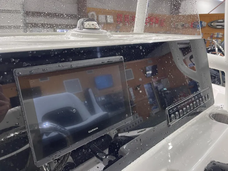 Slide: The Image of 2025 Tidewater 210LXF boat dashboard with Garmin display and control panel, wet with raindrops. - 21