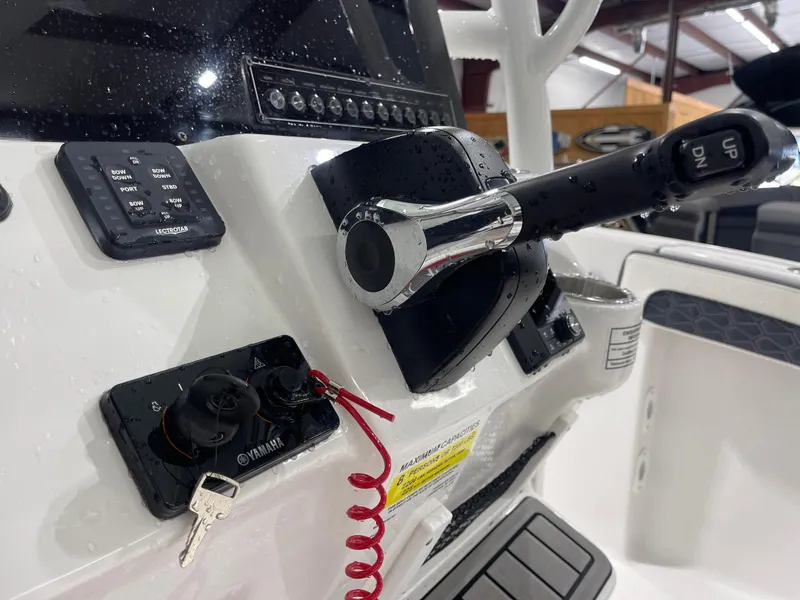 Slide: The Image of 2025 Tidewater 210LXF boat console with controls and Yamaha ignition key. - 23