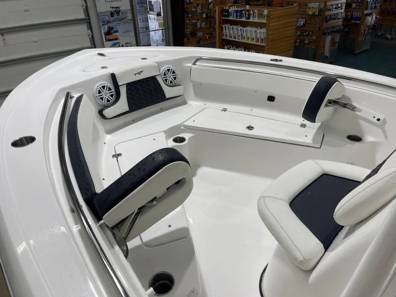 Slide: The Image of 2025 Tidewater 210LXF boat interior with white seating and speakers in a showroom. - 28