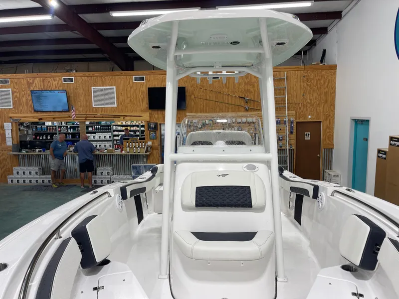 Slide: The Image of 2025 Tidewater 210LXF boat interior in showroom with seating and console. - 32