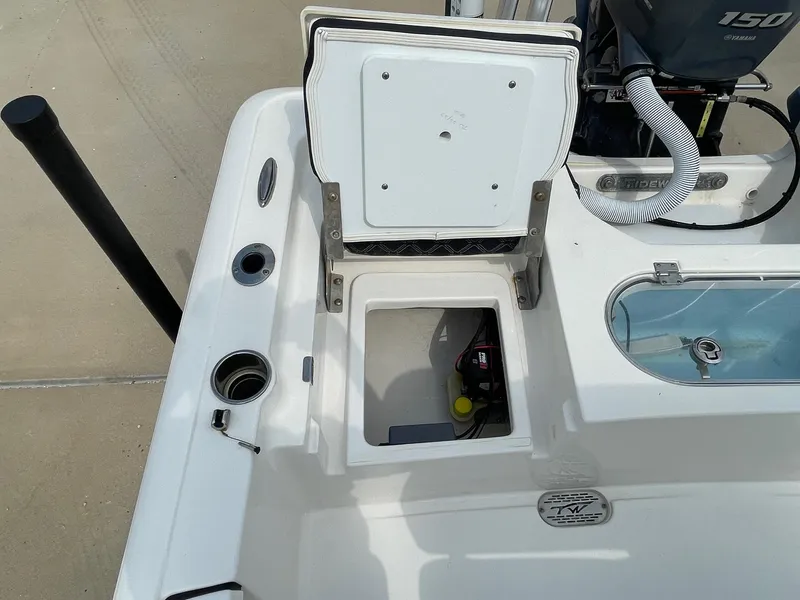 Slide: The Image of 2022 Tidewater 2110BM boat with open storage compartment and Yamaha 150 engine. - 12