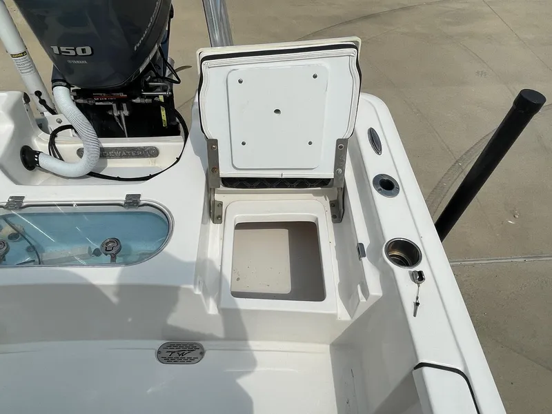 Slide: The Image of 2022 Tidewater 2110BM boat deck with open storage compartment and Yamaha 150 engine. - 17