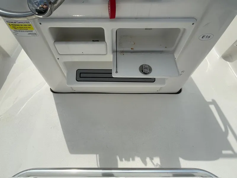 Slide: The Image of 2022 Tidewater 2110BM boat console with storage compartments and capacity label. - 26
