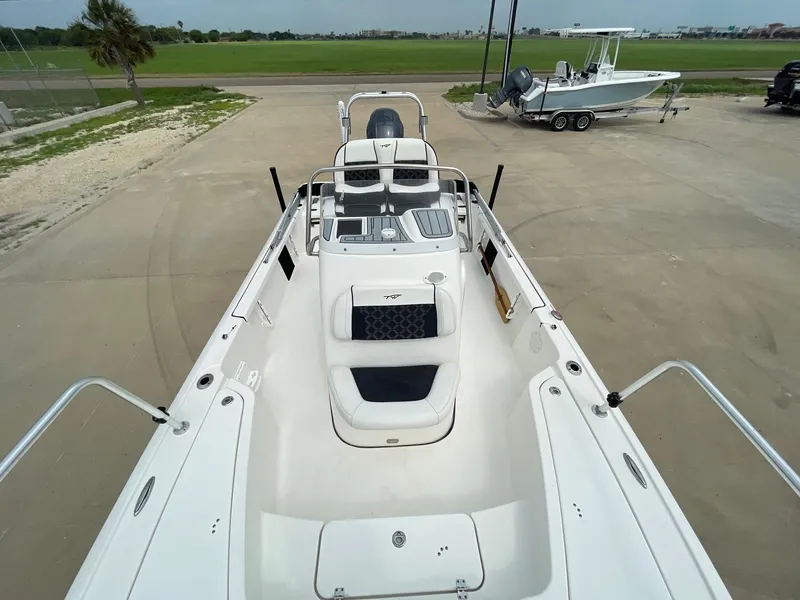 Slide: The Image of 2022 Tidewater 2110BM boat, white interior, parked on concrete near grass and another boat. - 29