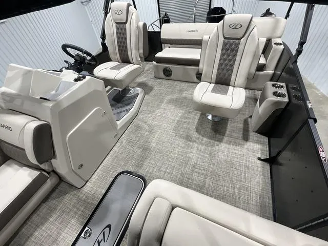 Slide: The Image of 2022 Harris SUNLINER 230 SLDH boat interior with plush seating and modern helm. - 9