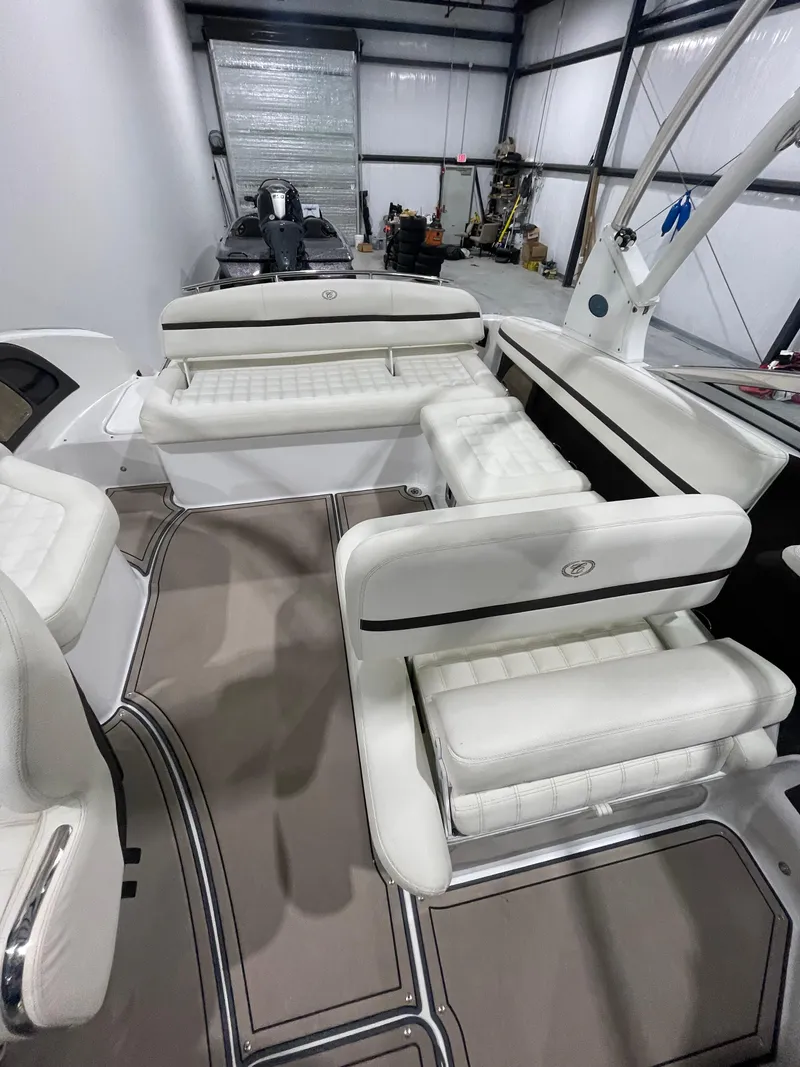 Slide: The Image of 2018 Cobalt R5 boat interior with white seating and modern design in a storage facility. - 13