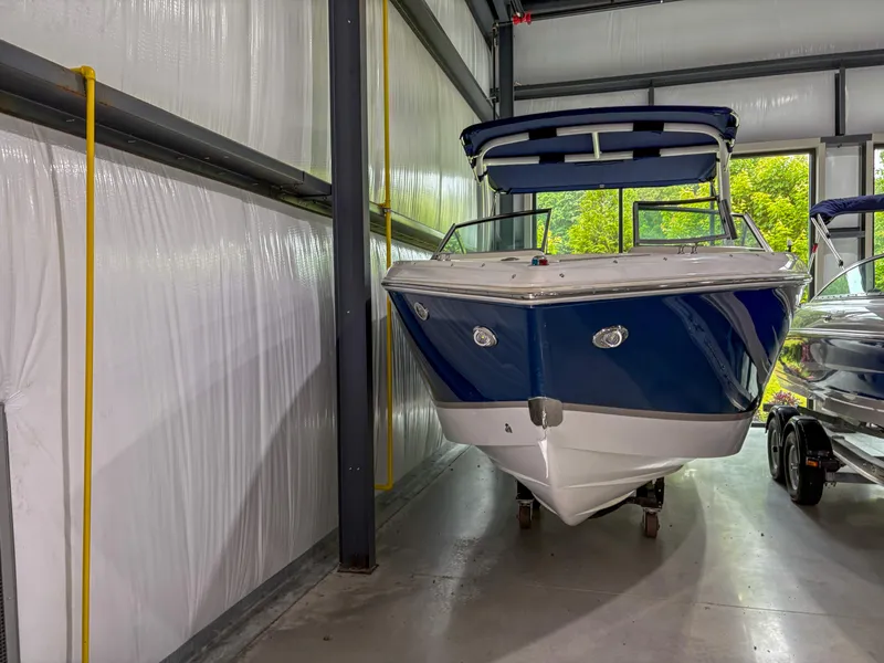 Slide: The Image of 2018 Cobalt R5 boat in storage, blue and white exterior, indoor facility. - 2