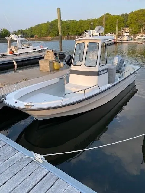 Slide: The Image of 2000 Maritime Skiff 2090 boat docked in a serene marina setting. - 1