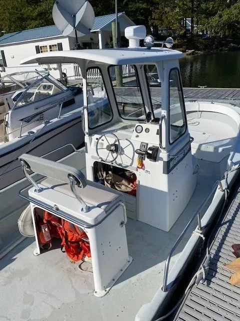 Slide: The Image of 2000 Maritime Skiff 2090 boat docked, featuring a central console and steering wheel. - 3