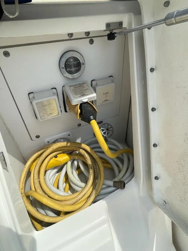 Slide: The Image of Electrical compartment of 2007 Sea Ray 310 Sundancer with coiled yellow power cables. - 13