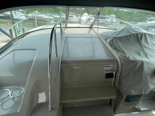 Slide: The Image of 2007 Sea Ray 310 Sundancer boat interior with covered seating and steps. - 18