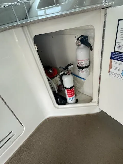 Slide: The Image of Fire extinguishers in storage compartment of 2007 Sea Ray 310 Sundancer boat. - 19