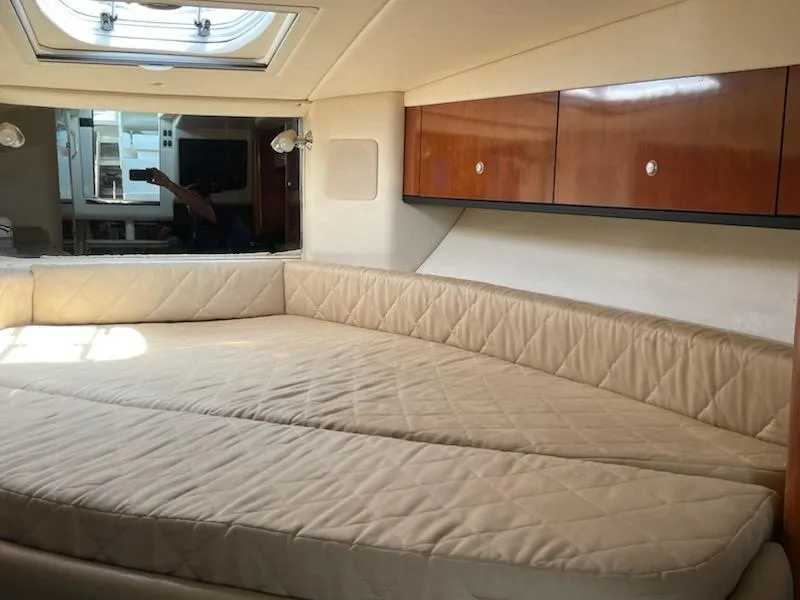 Slide: The Image of 2007 Sea Ray 310 Sundancer cabin with beige upholstery and wooden cabinets. - 29