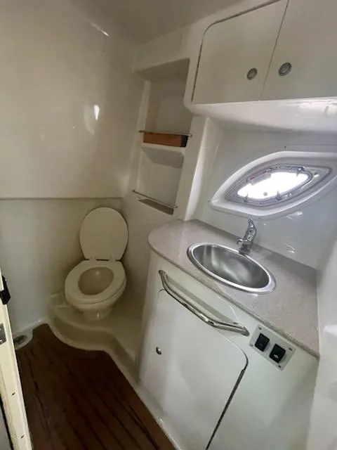 Slide: The Image of 2007 Sea Ray 310 Sundancer bathroom with toilet, sink, and storage cabinets. - 36